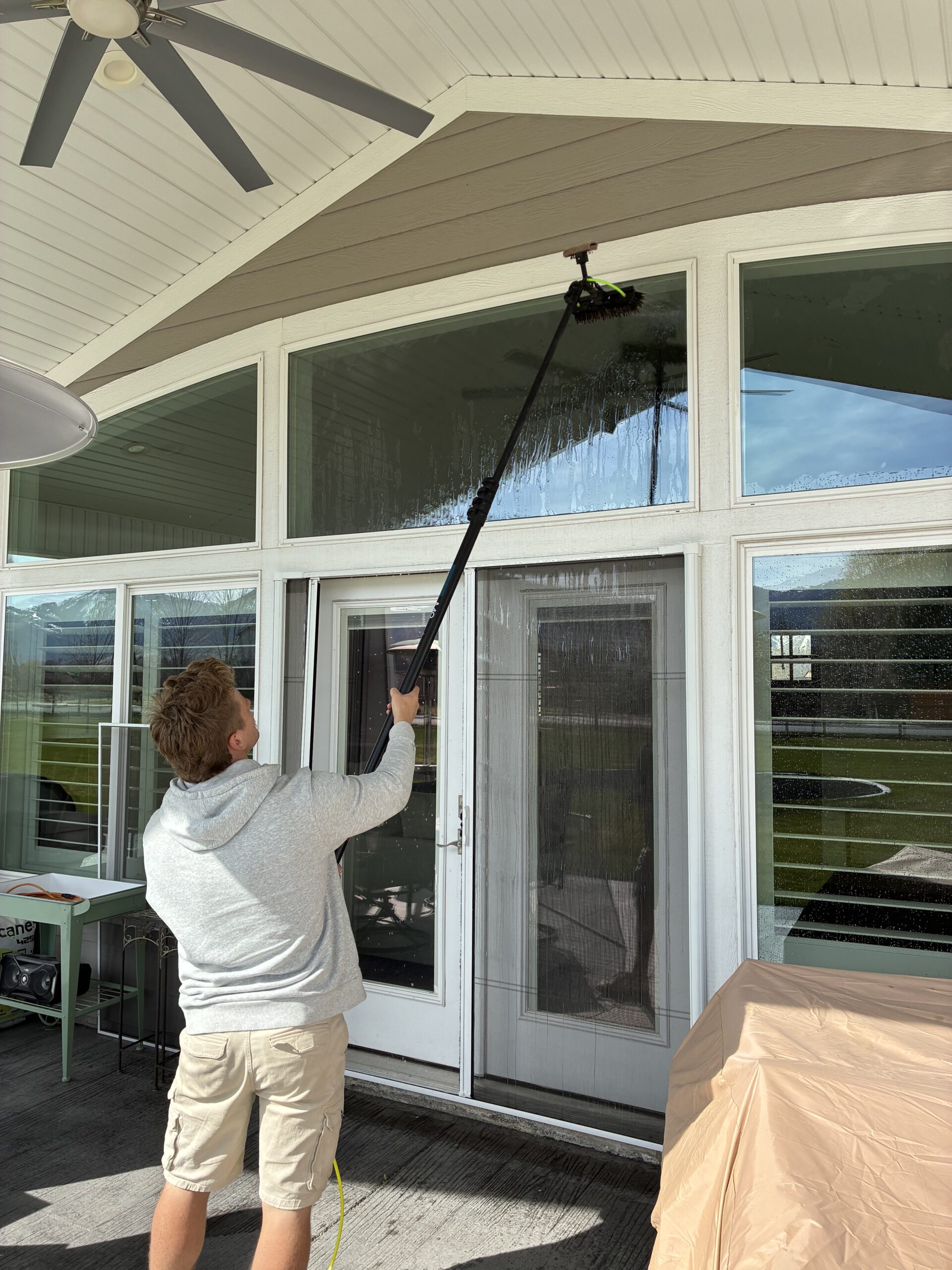 Person cleaning ceiling with pole