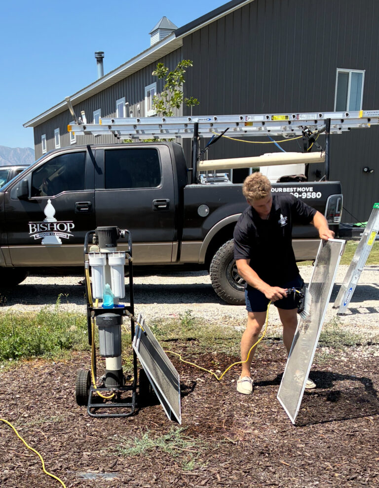 Person cleaning solar panels outdoors.
