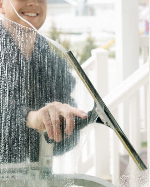 Person cleaning a glass window.