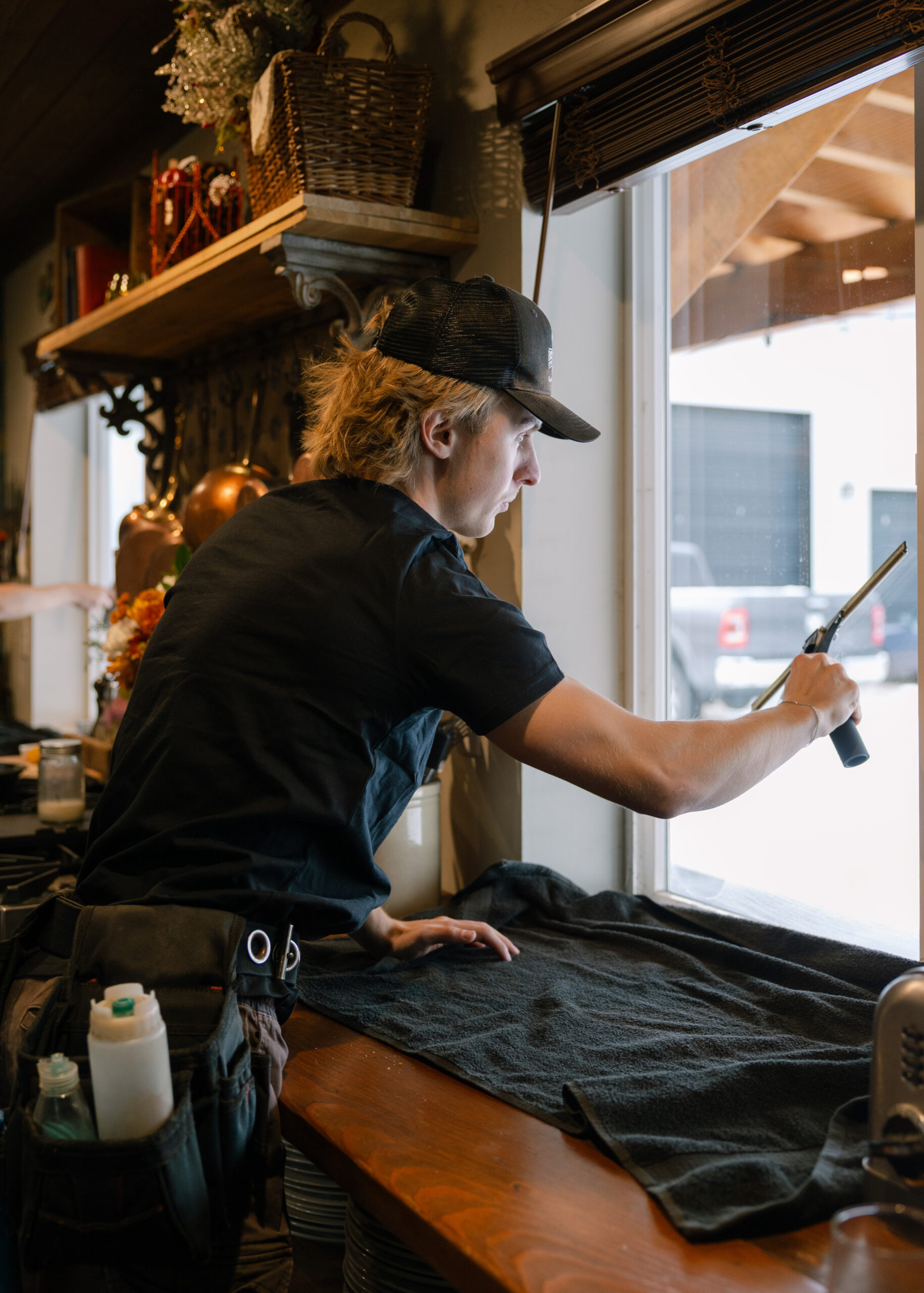 Person cleaning window in café.