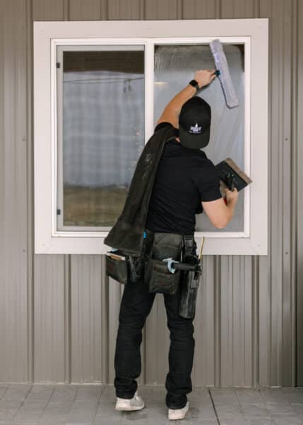 Person cleaning a window outdoors.